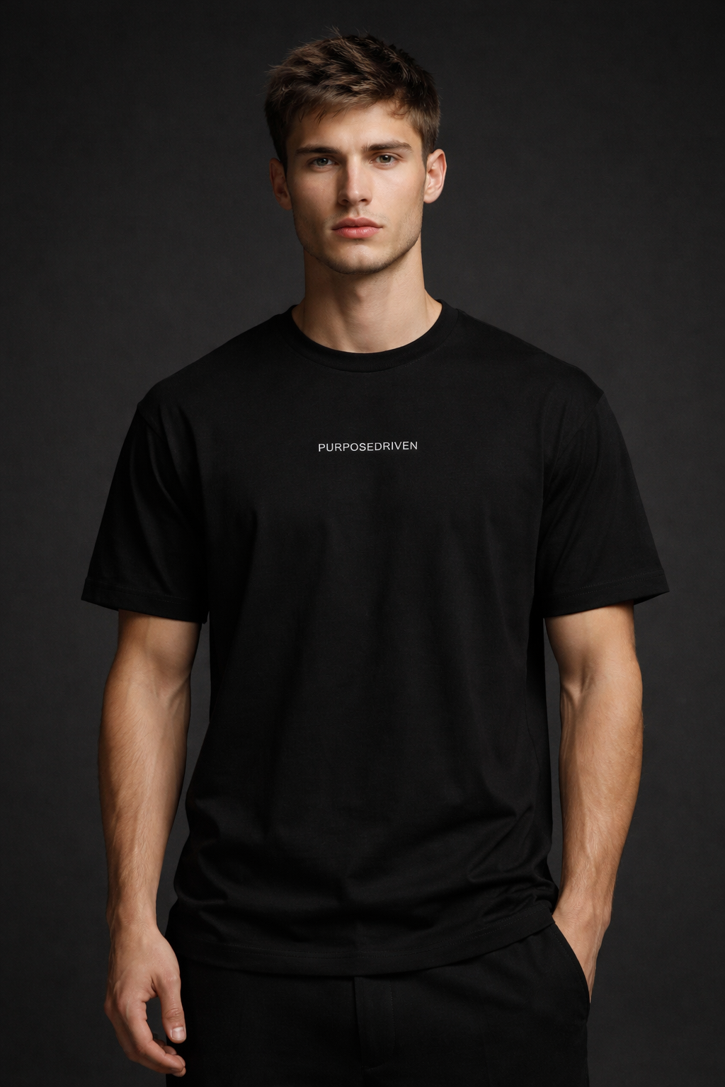 Male model wearing black PurposeDriven minimalist t-shirt, premium motivational streetwear on dark neutral backdrop