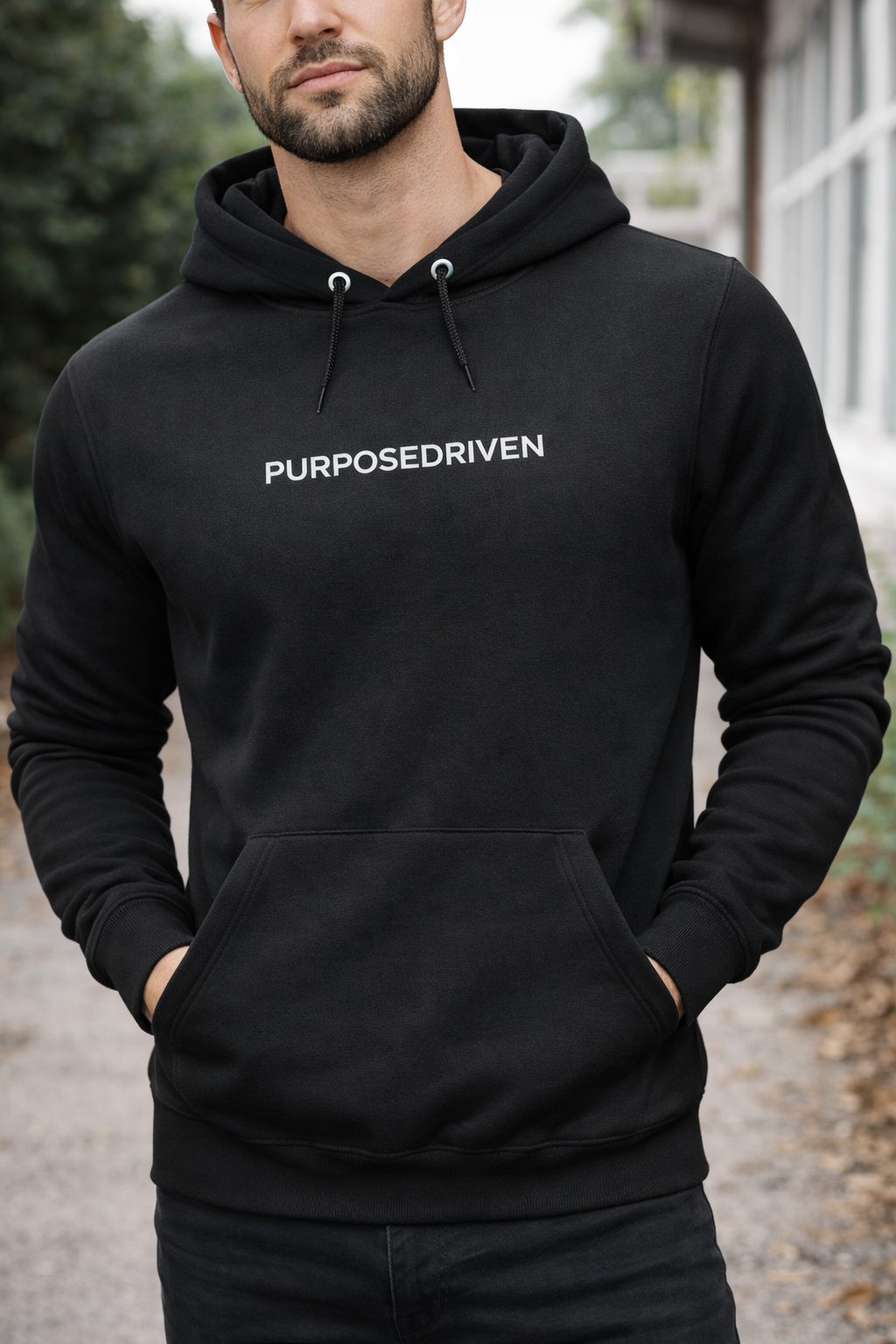 PurposeDriven minimalist black men’s hoodie worn by model in studio setting with clean modern fit