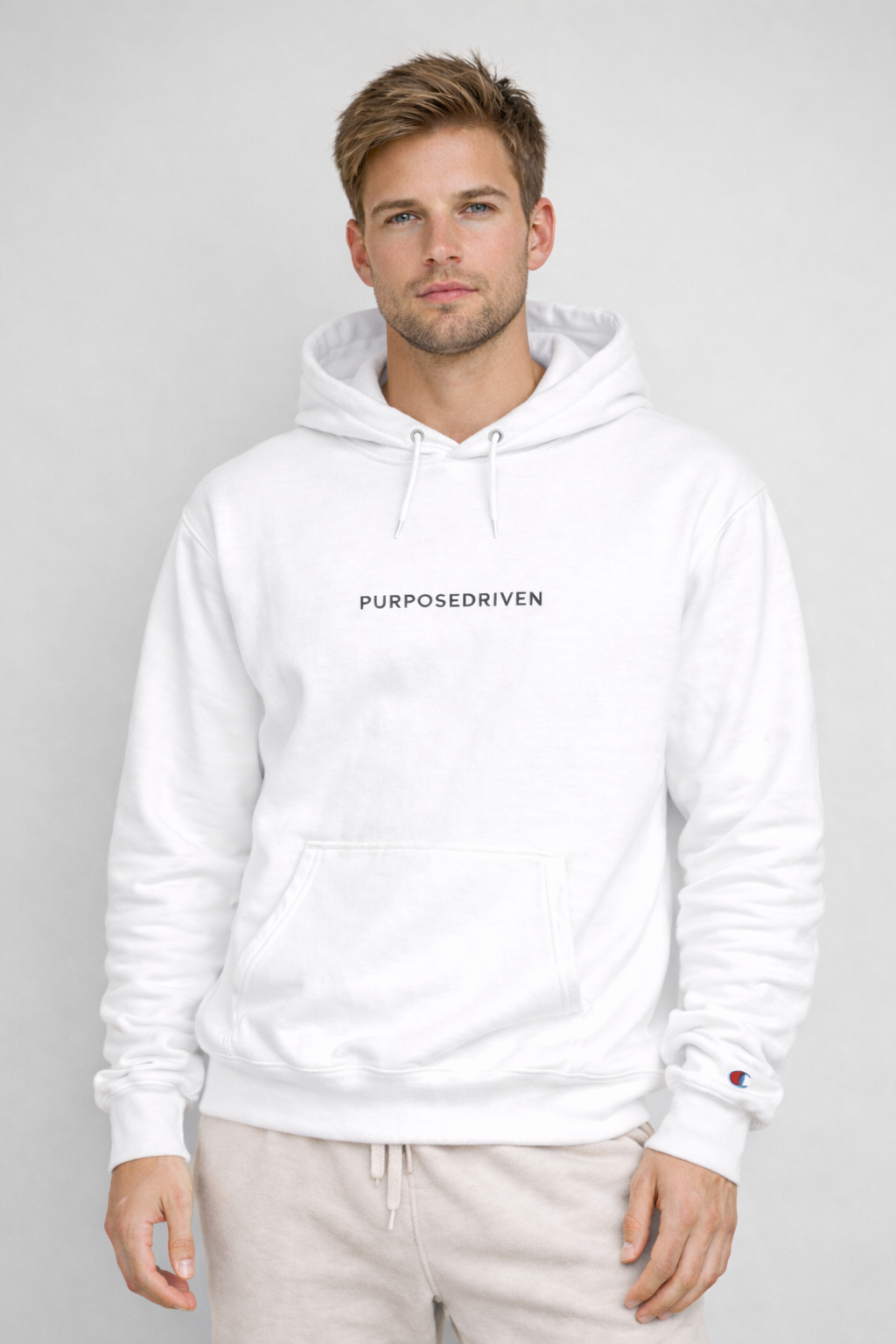 Male model wearing white PurposeDriven minimalist hoodie, modern motivational streetwear on clean neutral background