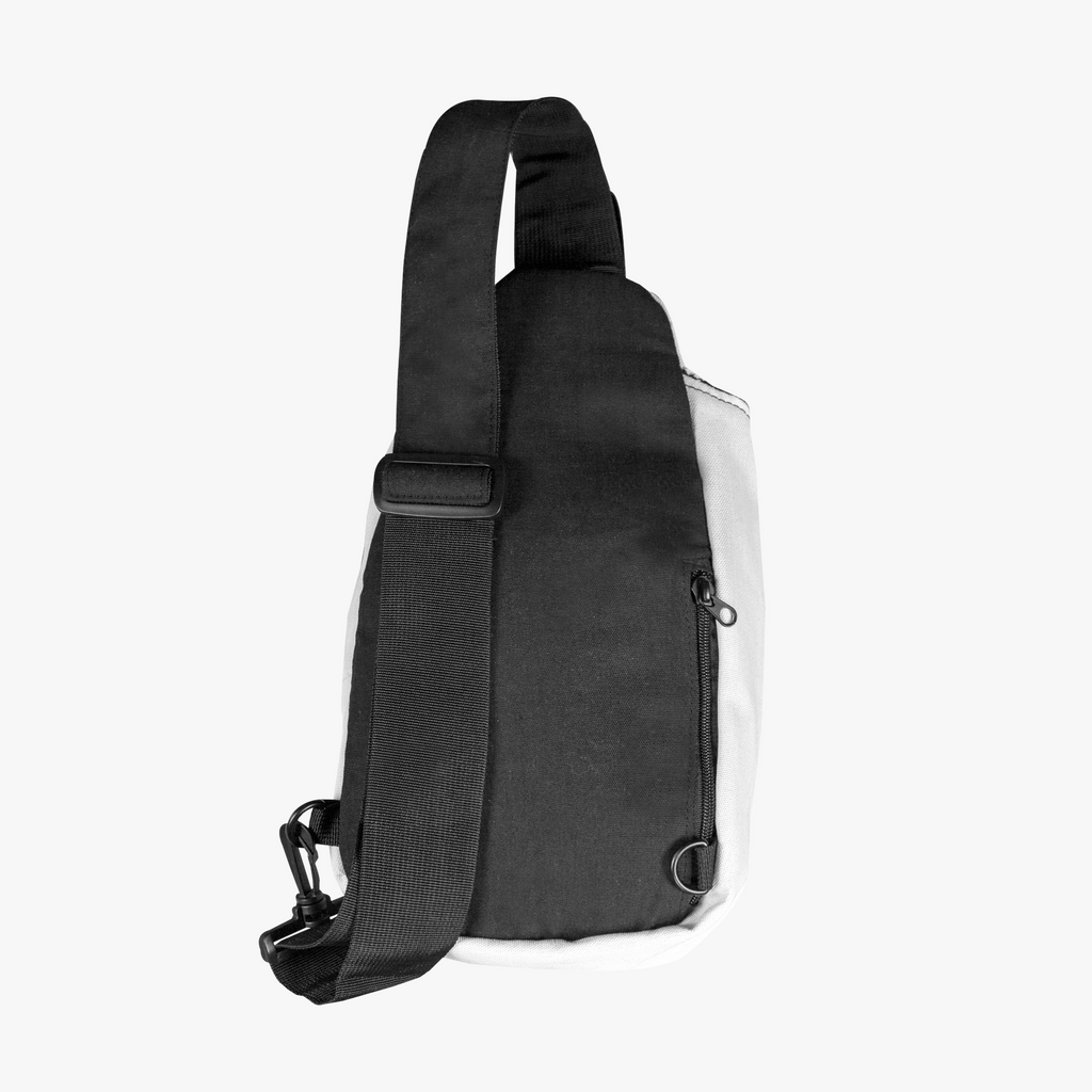 Back view of PurposeDriven™ minimalist white sling backpack with adjustable black strap on white background