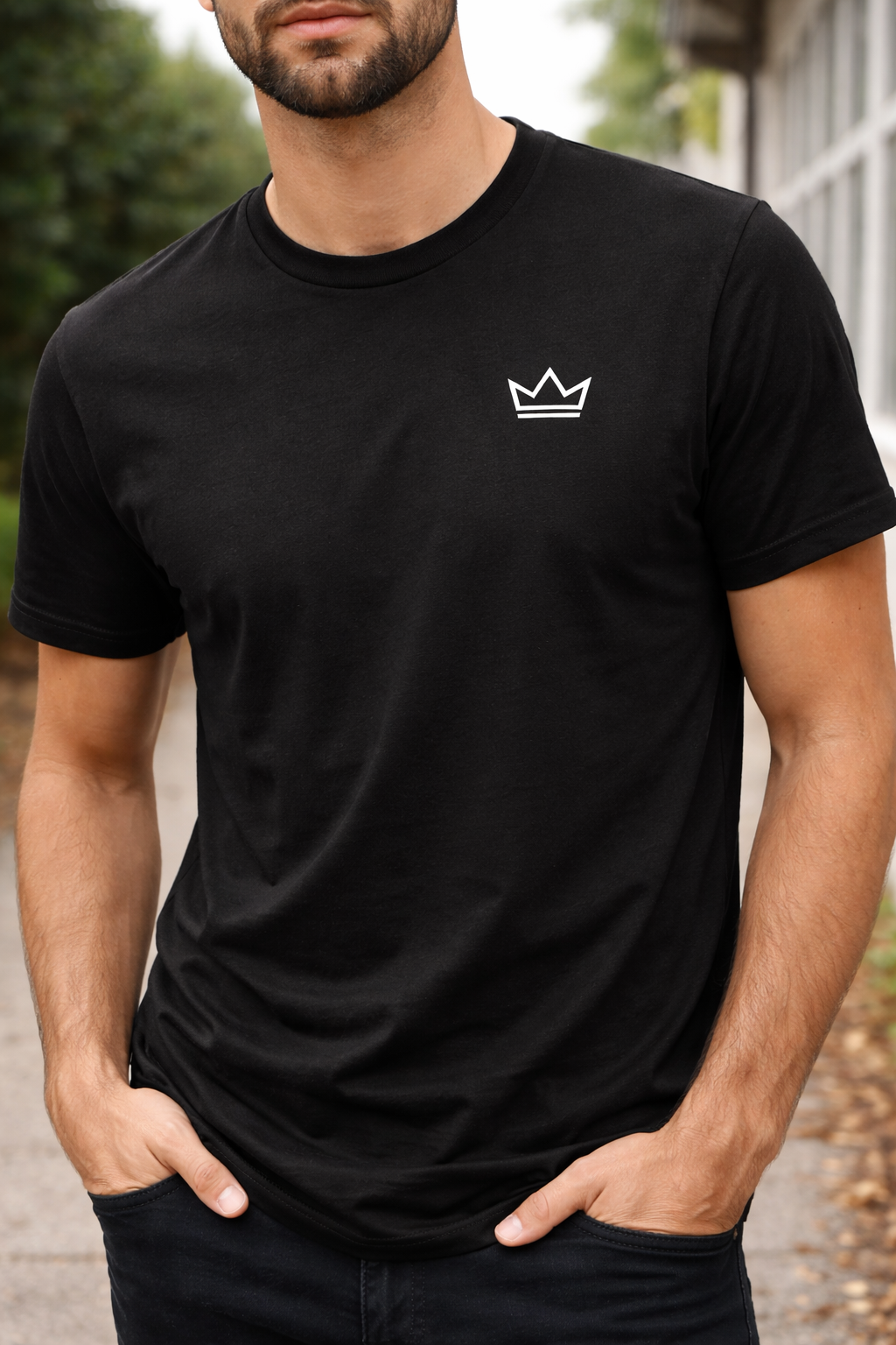 Male model wearing a black classic-fit t-shirt with small white crown logo, minimalist streetwear tee by PurposeDriven