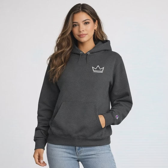 Female model wearing a charcoal grey heavyweight hoodie with a minimalist white crown logo, premium streetwear pullover with structured fit and soft fabric texture.